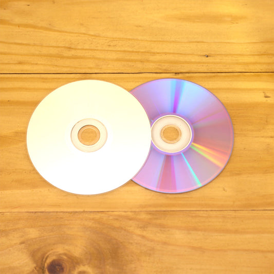 Un disco CD parcialmente sobre un  disco de DVD