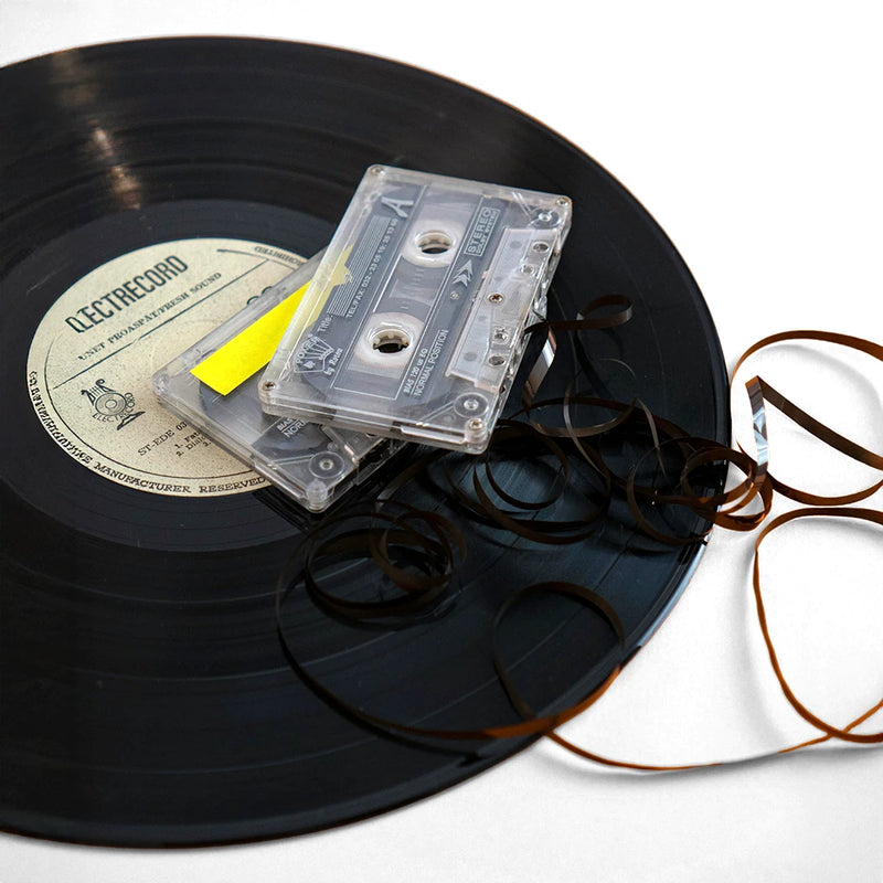 Disco de vinilo con casetes de audio y cinta deshilada