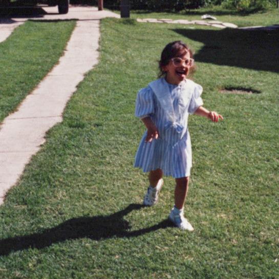 Niña corriendo por el pasto