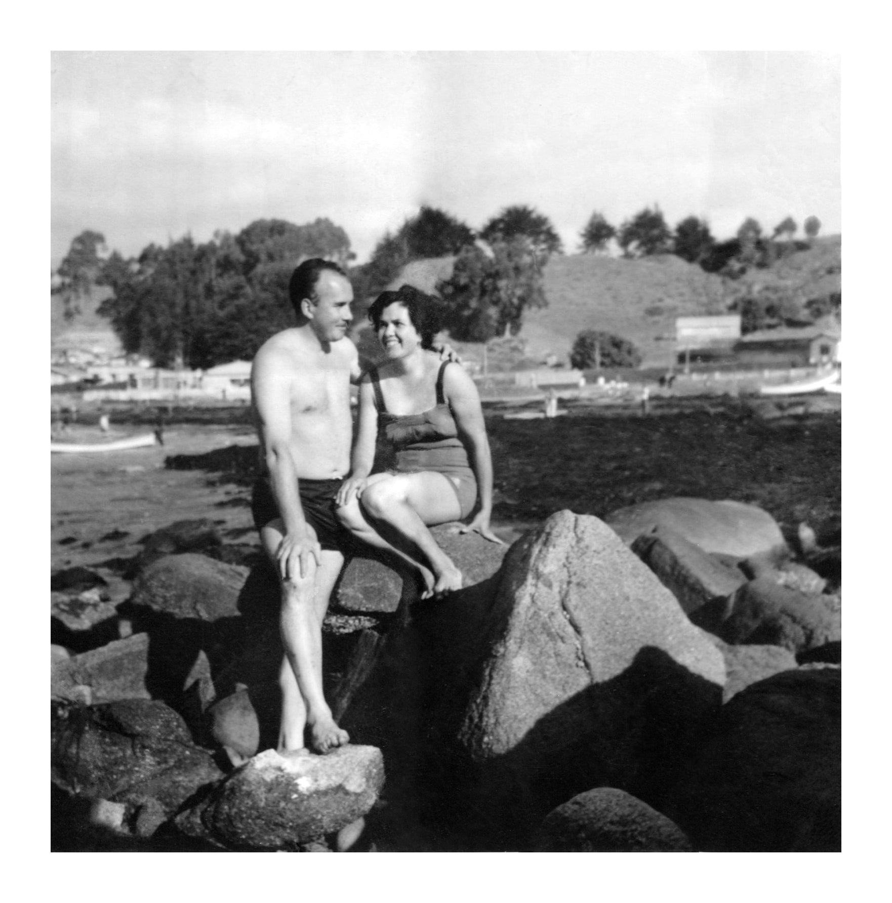 pareja posando en un roquerio en la playa